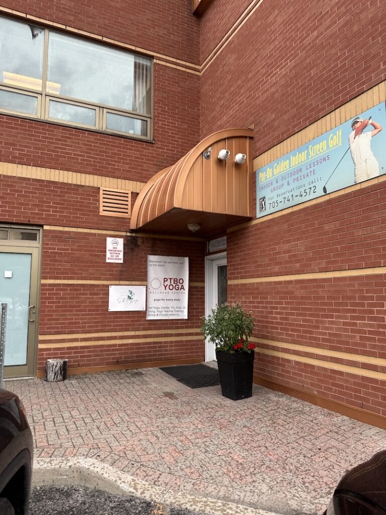 Exterior of Peterborough Yoga Wellness Centre with brick facade and entrance at the rear of building.